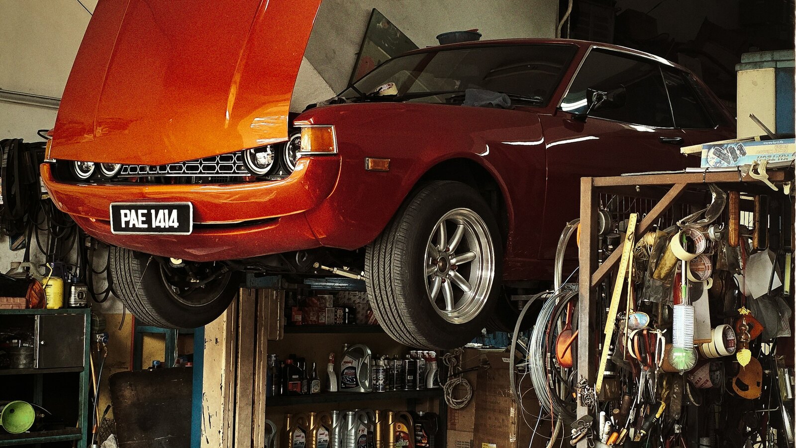 Mechanic working underneath a car on a garage lift